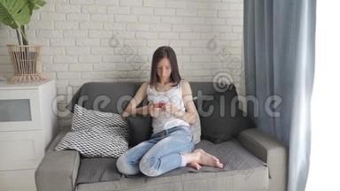年轻女子躺在沙发上，在智能手机上进行<strong>网上</strong>购物。 <strong>网上</strong>购物的概念。